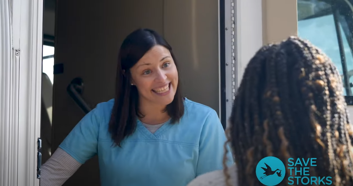 nurse welcomes a woman onto a bus