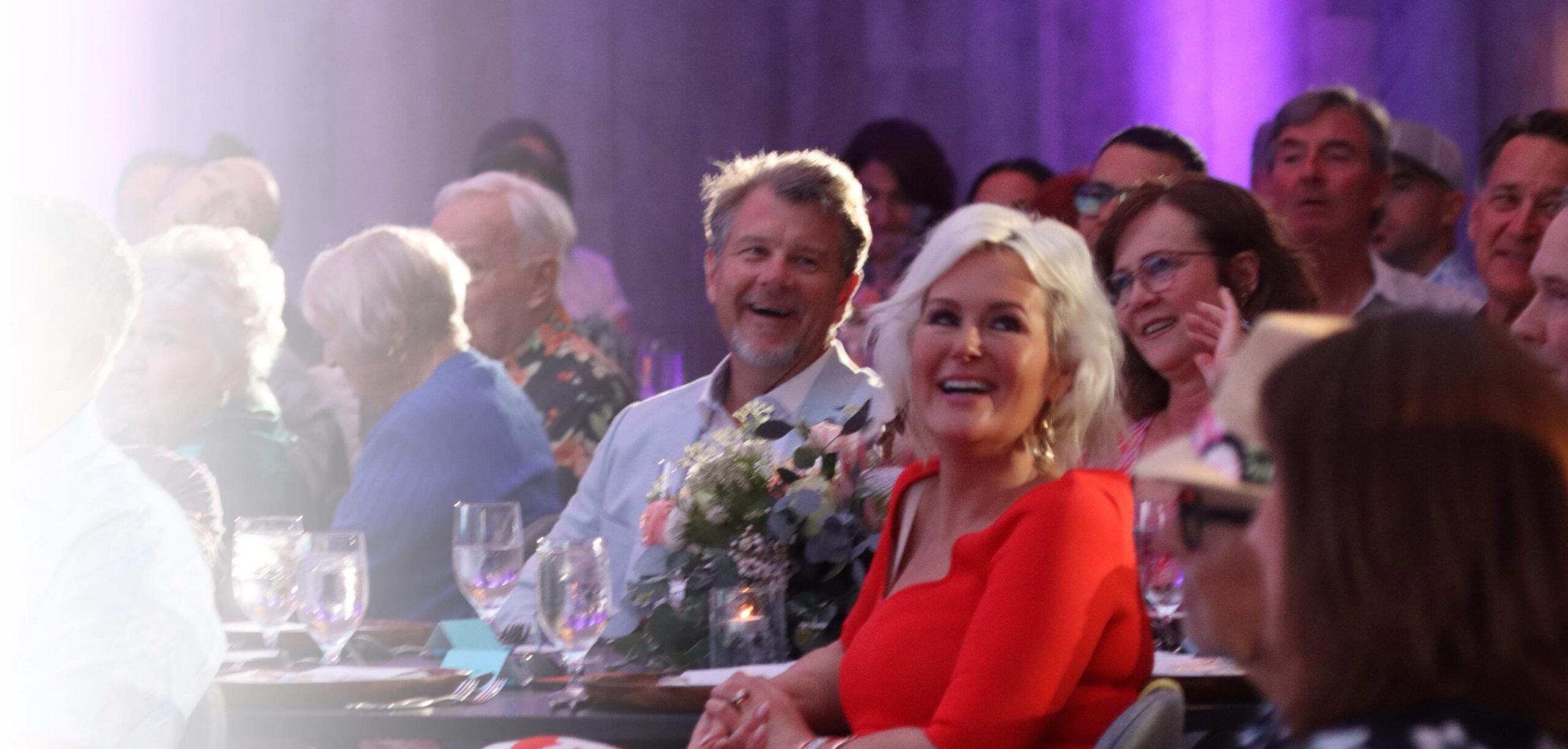 Many people at a conference dinner, smiling and laughing.